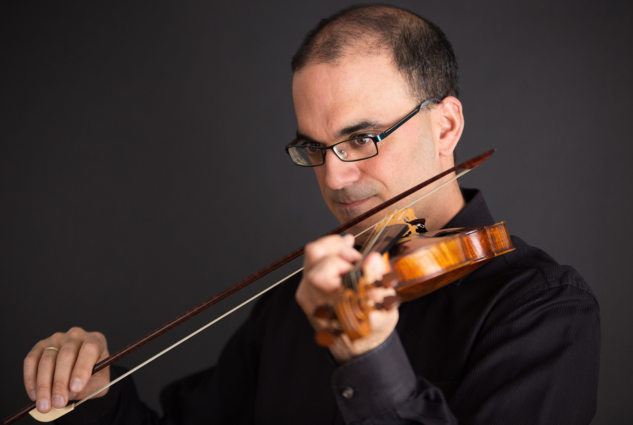 portrait of a male violinist on a black background