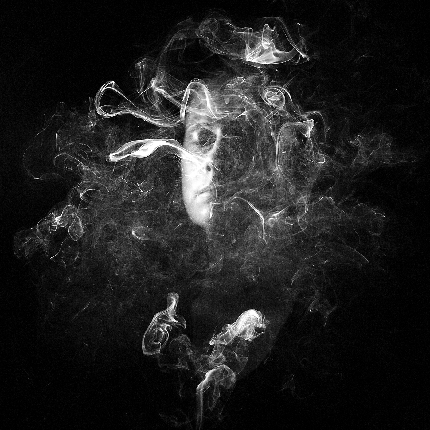 woman's face surrounded by smoke; black and white