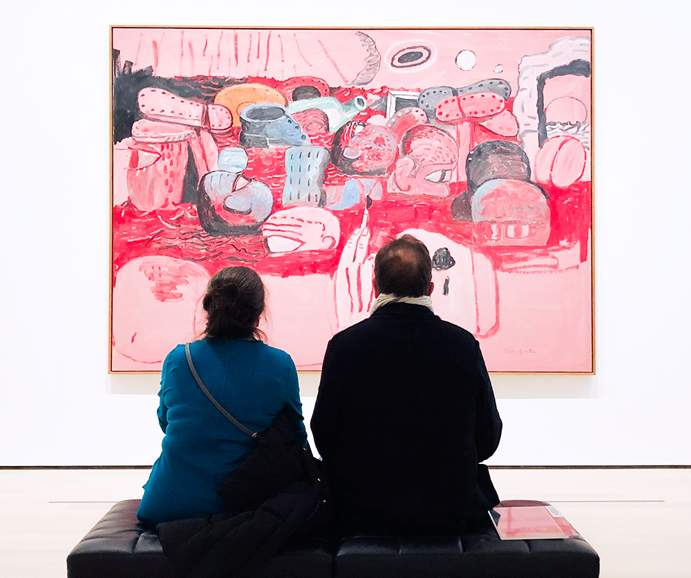 Two partners sitting together looking at a painting, reflecting emotional connection in a neurodiverse relationship